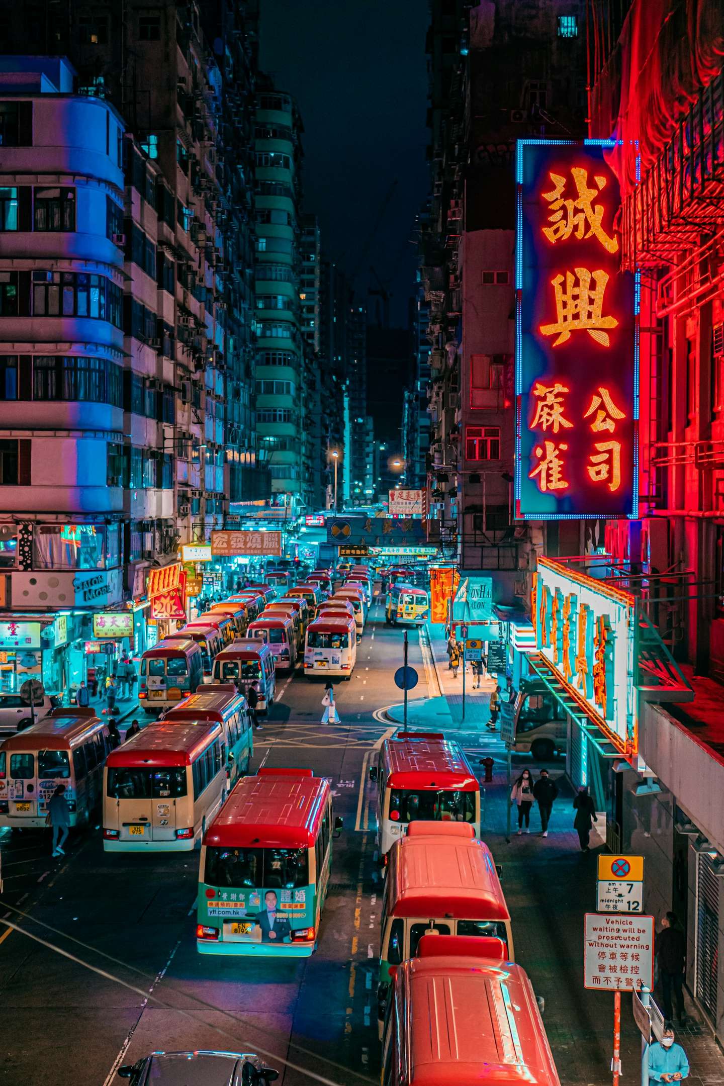 A Hong Kong street glowing with neon signs at dusk